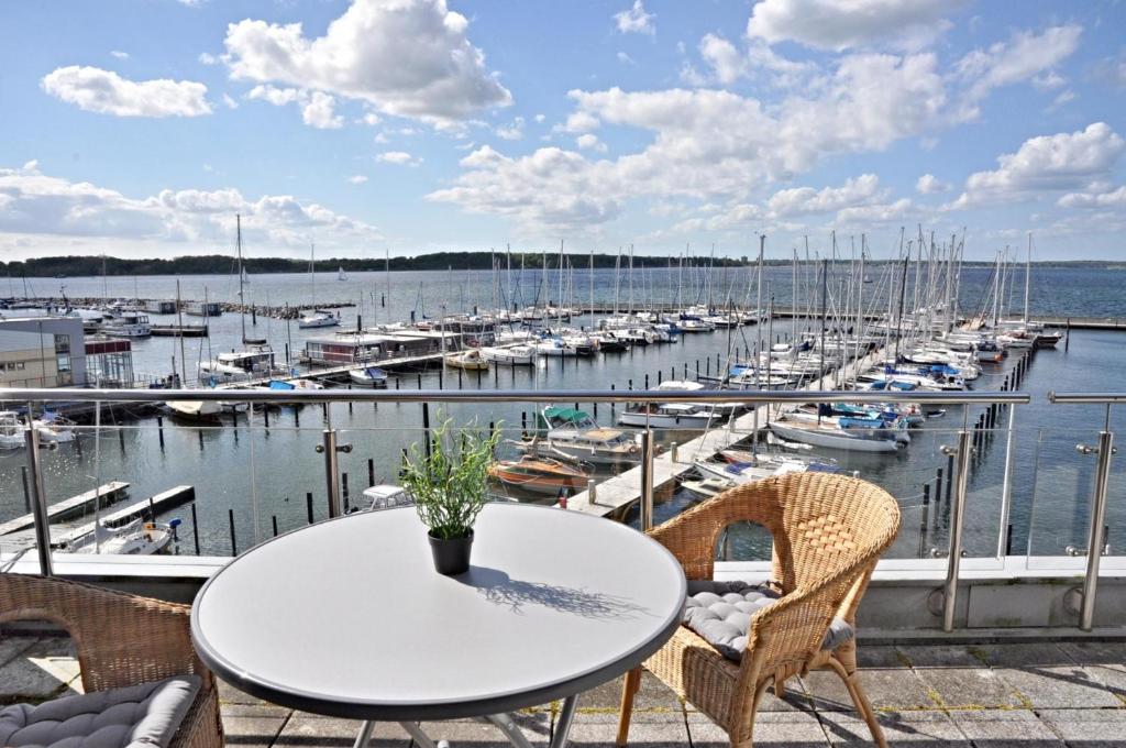 a table and chairs on a balcony with a marina at BRN Bootsmann in Laboe