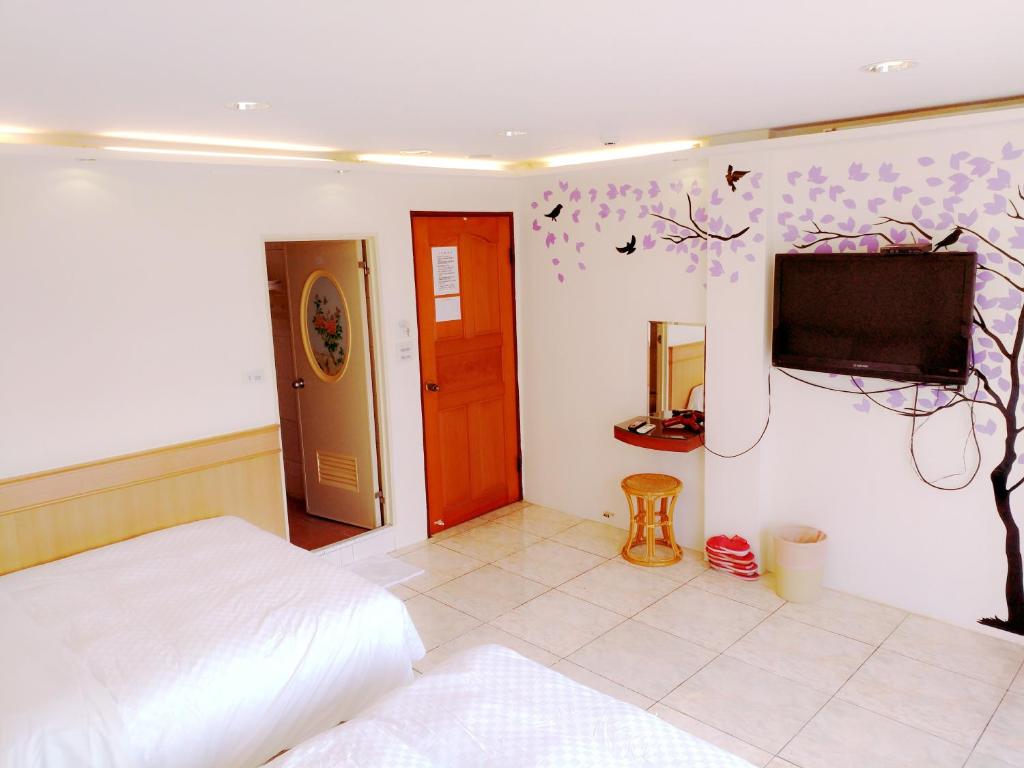 a bedroom with a bed and a flat screen tv at Hong Ben Hotel in Kenting