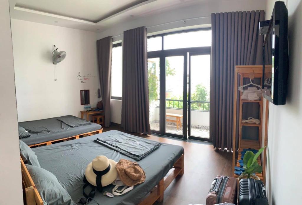 een slaapkamer met 2 bedden en een groot raam bij XAM HOUSE HOSTEL in Quy Nhon