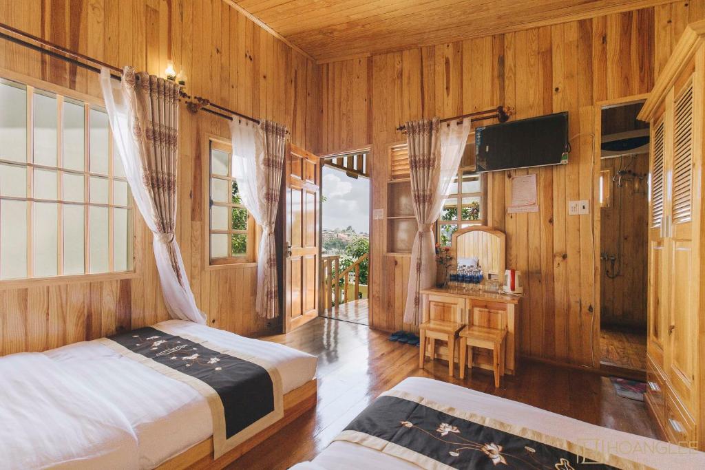 een slaapkamer met 2 bedden en een televisie. bij Danh Tien Villa in Da Lat