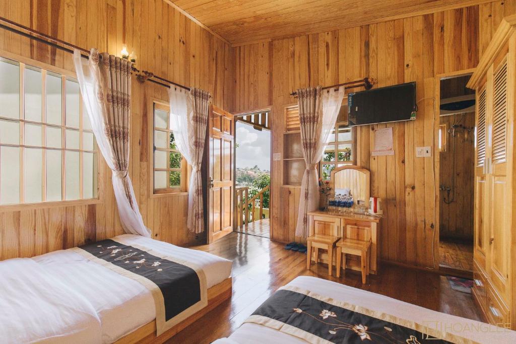 a bedroom with two beds and a television in it at Danh Tien Villa in Da Lat