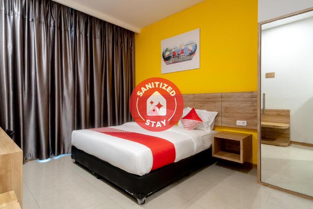 a bedroom with a bed with a red sign on it at Super OYO 3159 Festive Inn in Medan