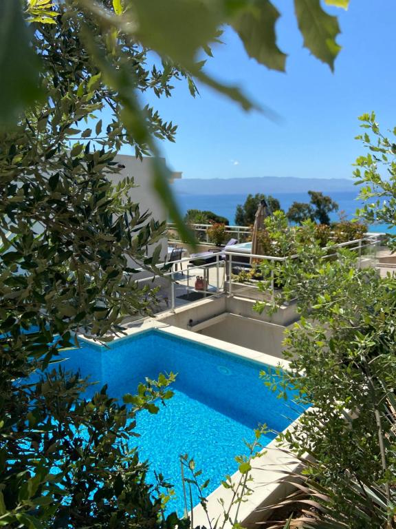 a pool with a view of the ocean through trees at VIzzavona piscine et jacuzzi in Ajaccio