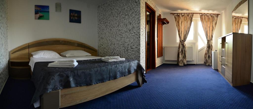 - une chambre avec un lit et des serviettes dans l'établissement La Mateo, à Călimăneşti