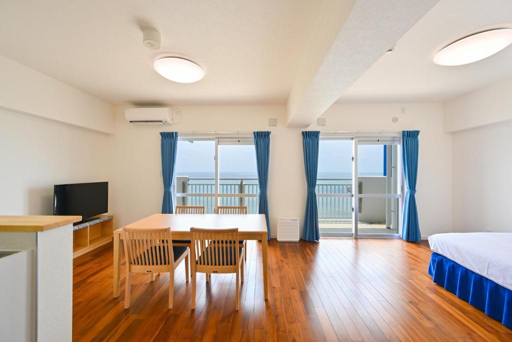 a bedroom with a table and chairs and a bed at Daily & Weekly Condominium BLUE OCEAN ISHIGAKI in Ishigaki Island