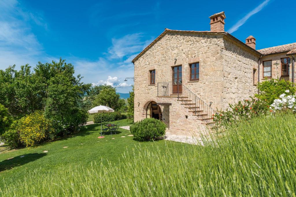 una antigua casa de piedra con un patio de césped en Borgo Fastelli - House in historical Borgo in Tuscany - Susino, en Sarteano