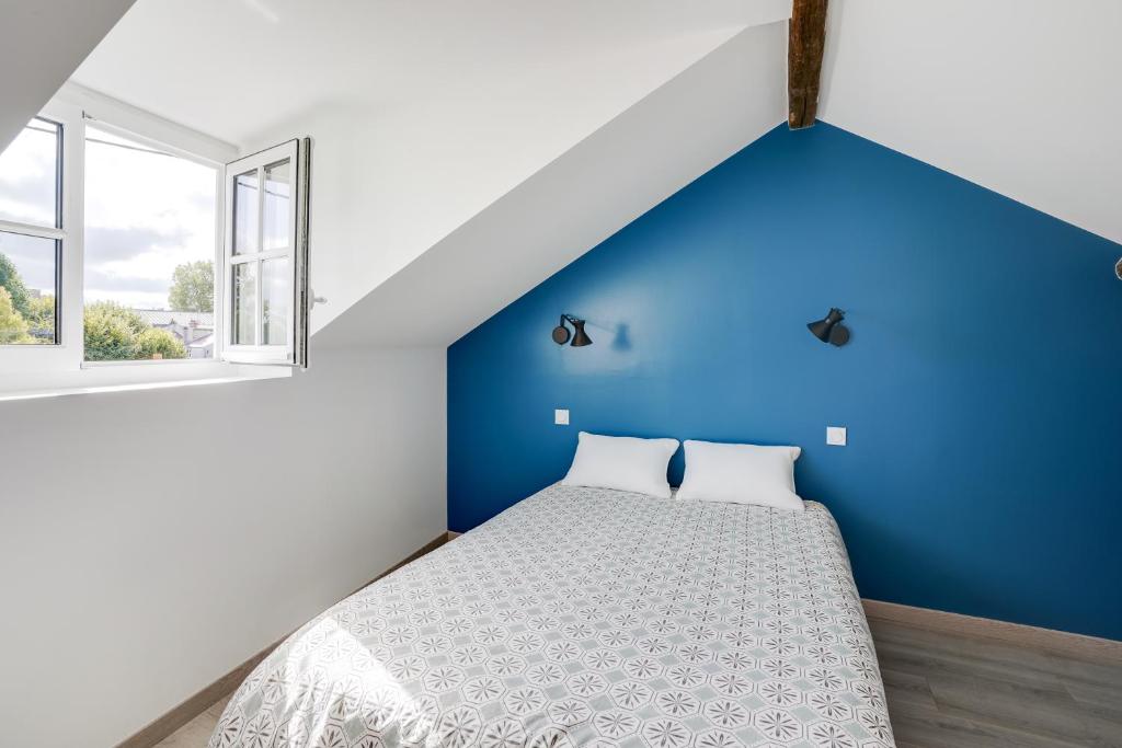 una camera da letto con una parete blu e un letto di Charme et Design à Proximité du Château a Fontainebleau