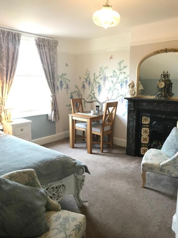 a bedroom with a bed and a table and a mirror at Anchorage House in Whitby