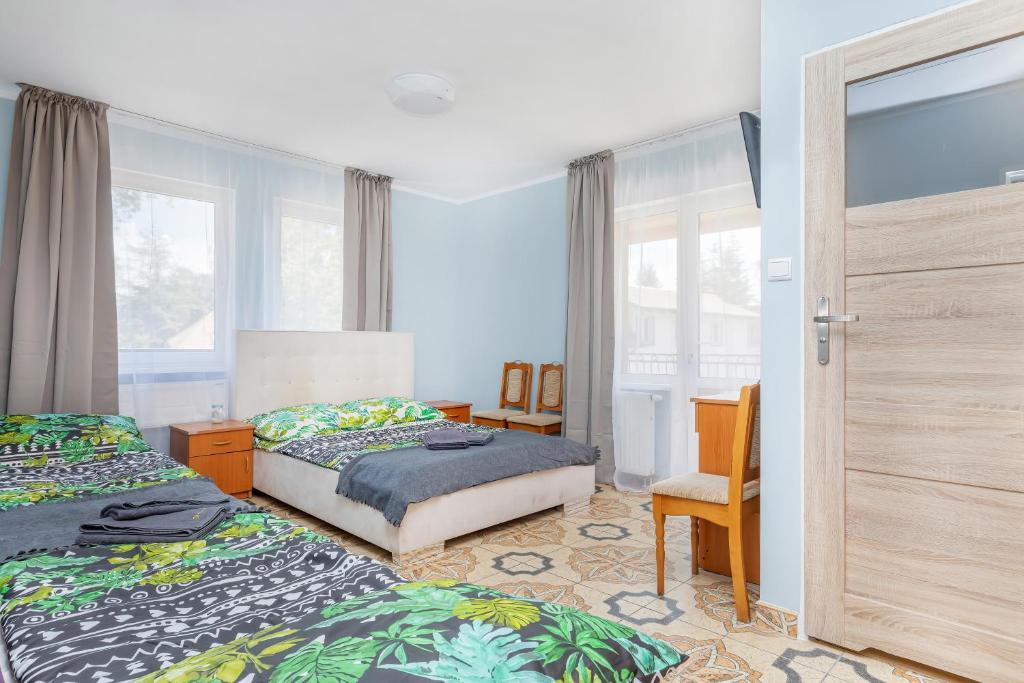 a bedroom with two beds and a sliding glass door at Panorama in Pobierowo