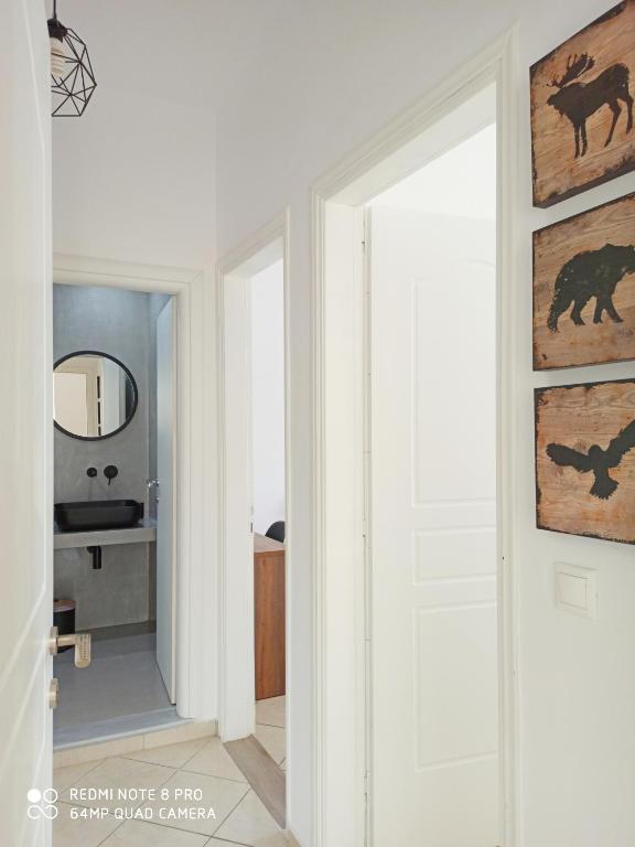 um corredor com uma porta branca e um espelho em Bourbos Summer Rooms em Himare