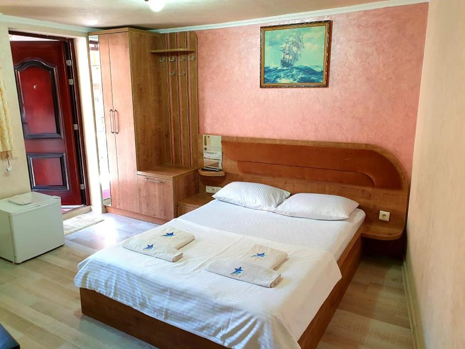 a bedroom with a bed with two towels on it at Hotel Old Star in Batumi