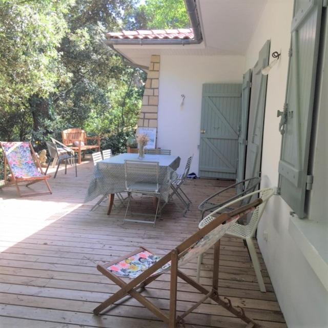 un patio avec une table et des chaises sur une terrasse dans l'établissement Villa Framboise, à Lège-Cap-Ferret