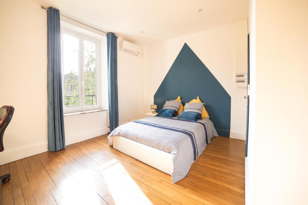a bedroom with a bed with blue walls and a window at Le P'tit Dupont - Logements Insolites in Nancy