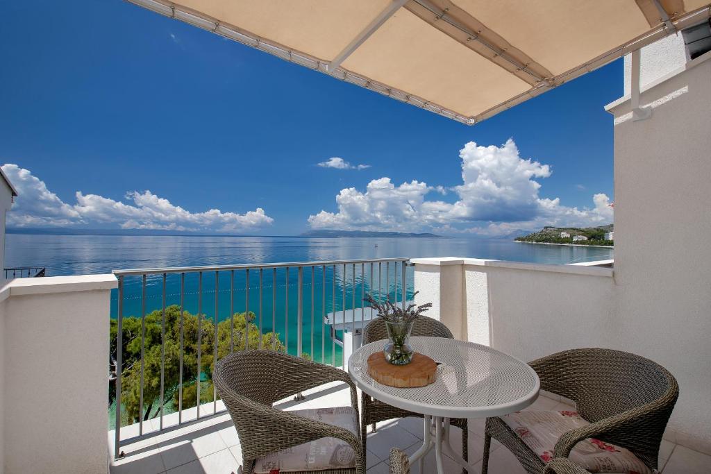 a balcony with a table and chairs and a view of the ocean at Apartman Ratac 11 in Tučepi