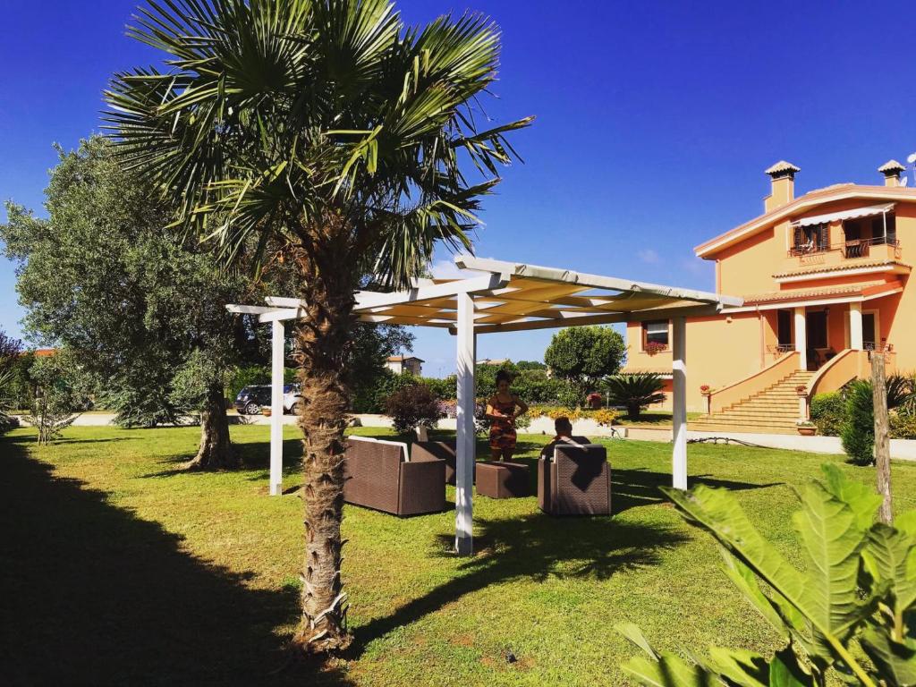 a palm tree and a pergola in front of a house at Villa Laregina in Grisolia