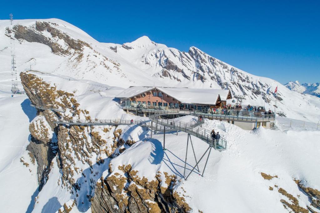 domek narciarski na szczycie pokrytej śniegiem góry w obiekcie Berggasthaus First - Only Accessible by Cable Car w mieście Grindelwald