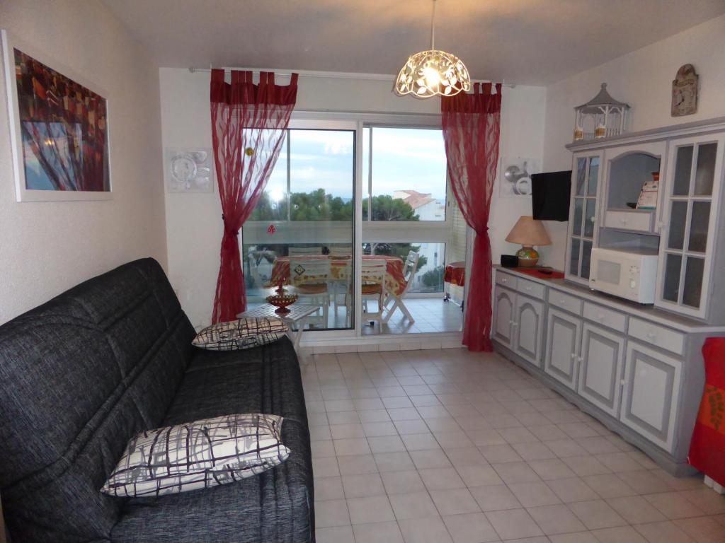 - un salon avec un canapé et un four micro-ondes dans l'établissement APPT 1 CHAMBRE QUARTIER DES PLAGES, à Sète