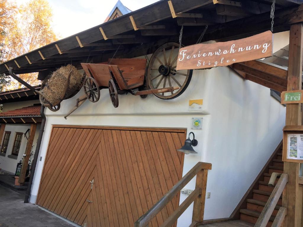 un edificio con una porta da garage in legno con un carro sopra di Ferienwohnung Stigler a Eisenberg
