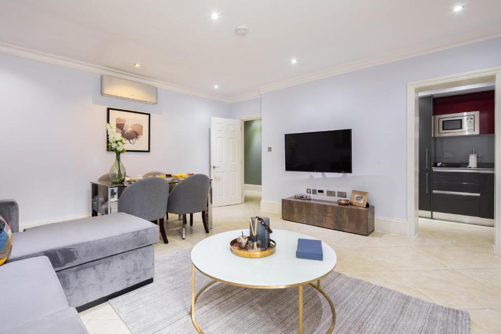 a living room with a couch and a table at Lancaster Gate Hyde Park by London Hotel Collection in London