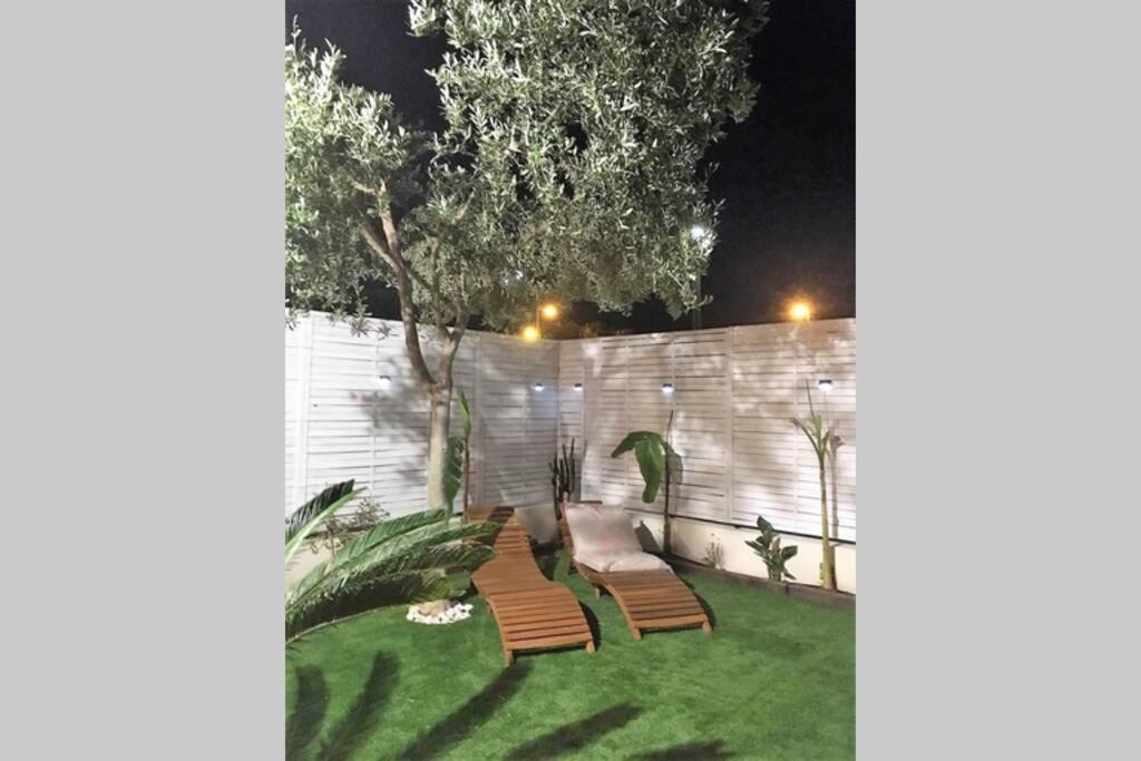 un cortile con due sedie e una recinzione di notte di Chill out ground floor apartm +private garden+WIFI a Retamar