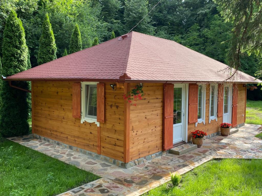 a small wooden cabin with a red roof at Brvnara kraj Dunava Zelena Oaza in Banoštor