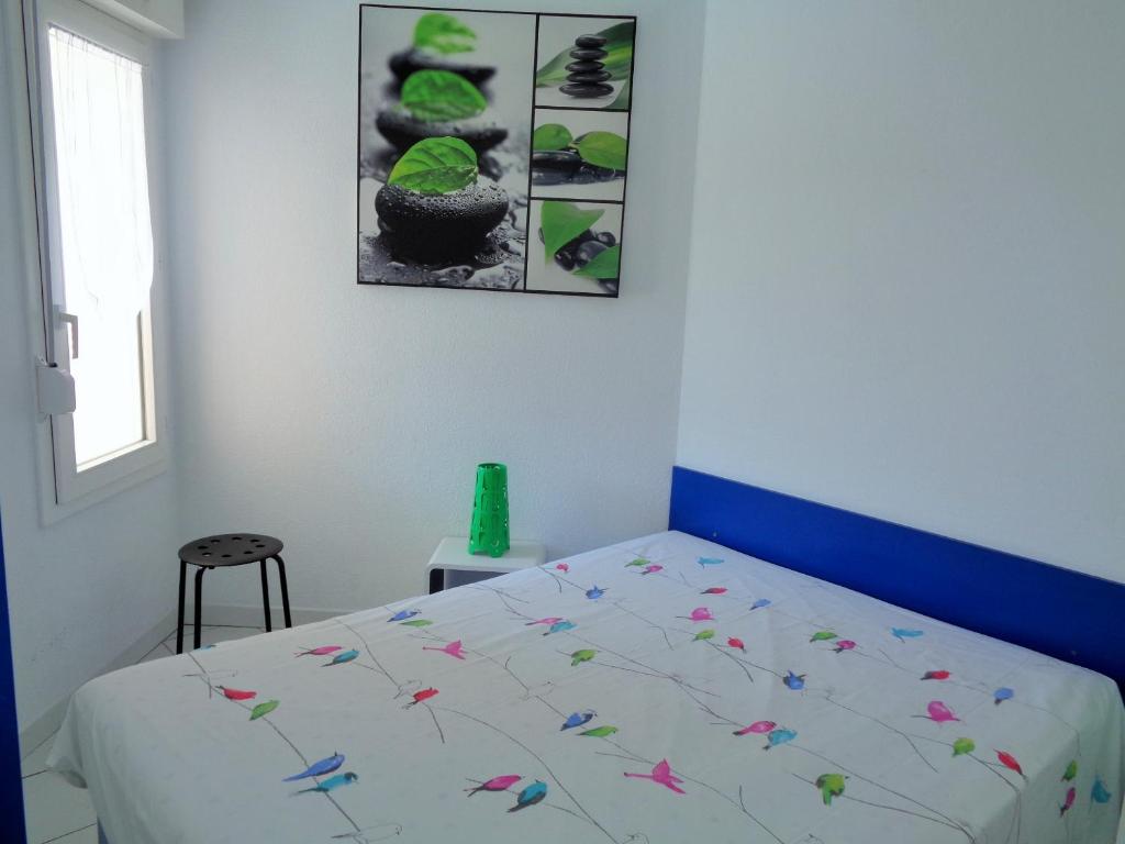 - une chambre avec un lit fleuri dans l'établissement 1 CHAMBRE, VUE MER, ACCES DIRECT PLAGE, à Sète
