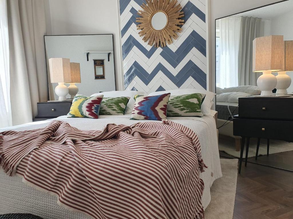una camera da letto con un letto e un grande specchio di THE MIRROR GUESTHOUSE - TERME MERANO a Merano