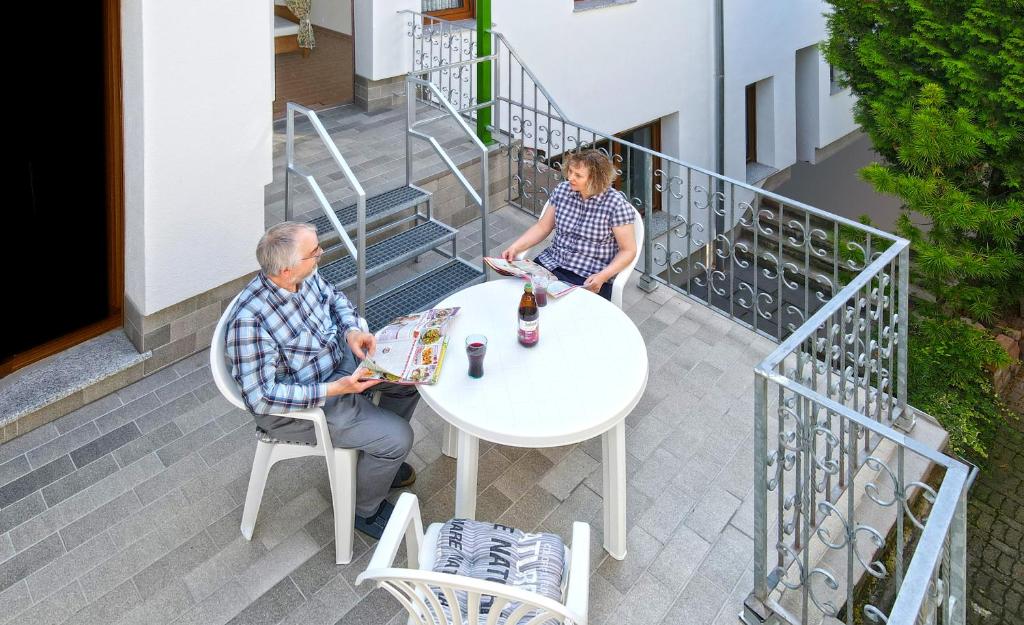 two people sitting at a table on a balcony at Himmelbett-Ferienwohnung Oberwesel in Oberwesel