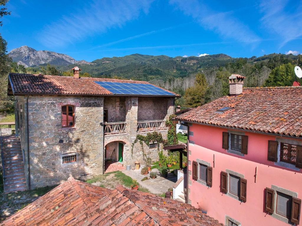 een oud huis met zonnepanelen op het dak bij Agriturismo Il Corniolo in Castiglione di Garfagnana