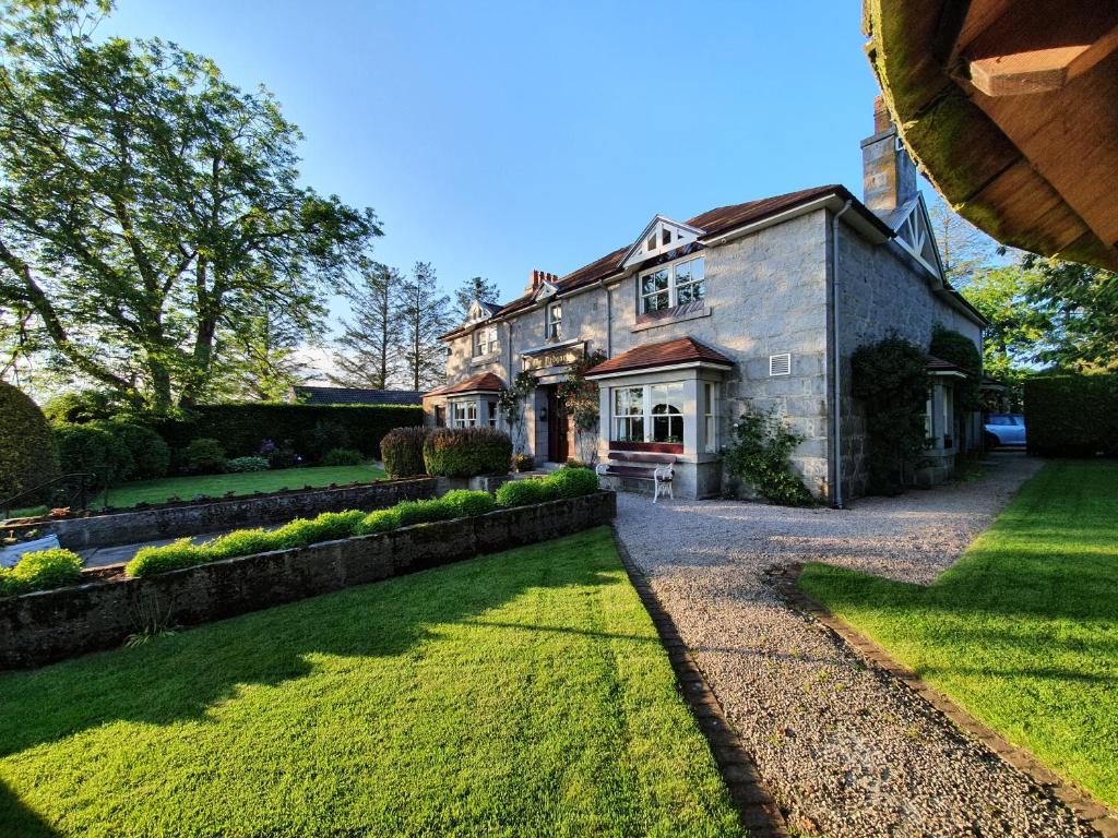 a large brick house with a lawn in front of it at The Redgarth in Oldmeldrum