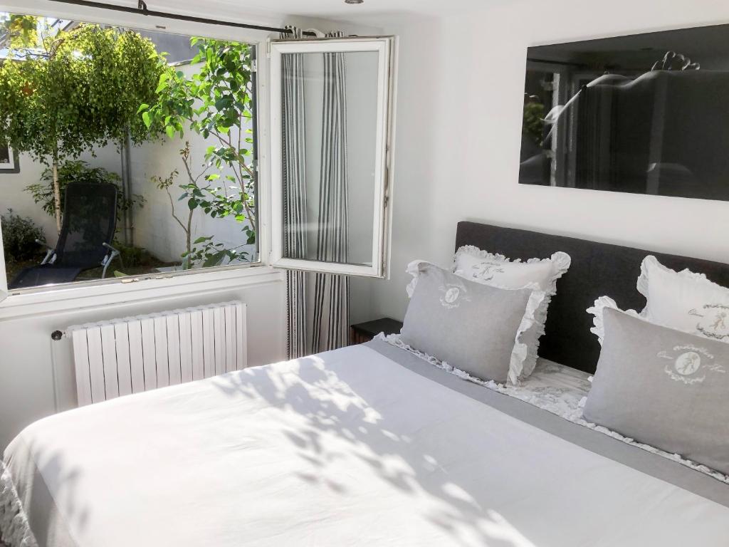 サン・マロにあるLa Suite Nolyvanのベッドルーム1室(白いシーツと枕のベッド1台付)