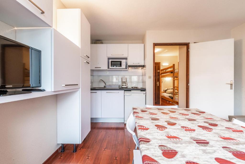 a room with a bed and a kitchen with white cabinets at Meilleur emplacement hypercentre avec parking privatif souterrain in Chamonix