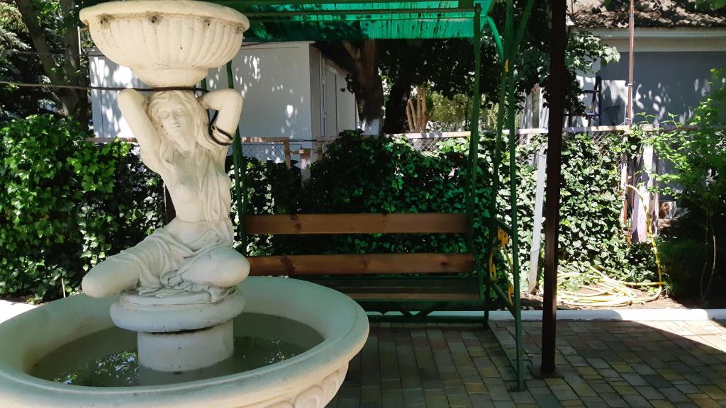 a statue of a girl sitting on top of a fountain at Зюйд in Gribovka
