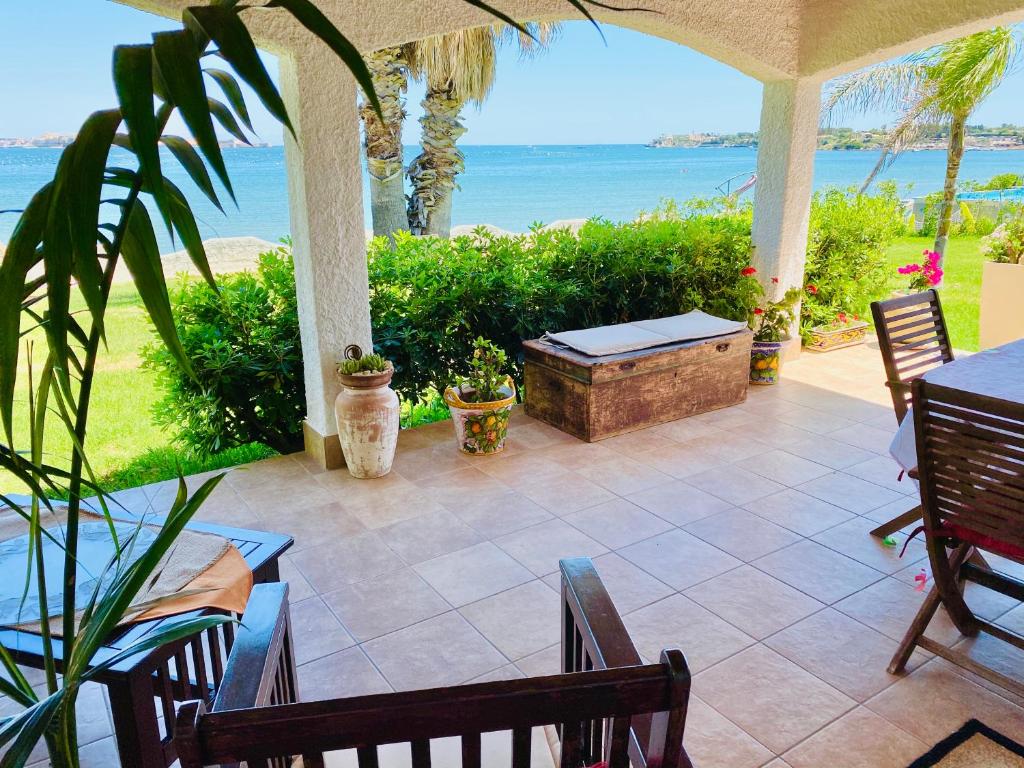 a patio with a table and chairs and the ocean at Villa Incanto on the Sea in Syracuse