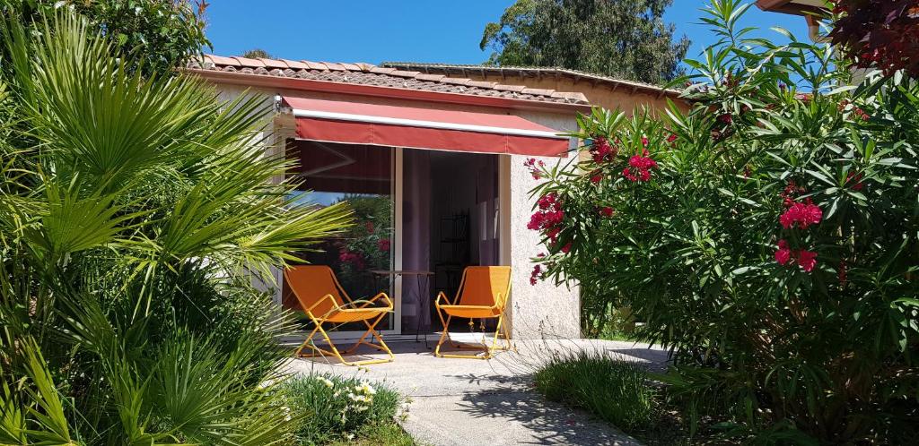 dos sillas sentadas en el porche de una casa en Chambre d'hôte Kalango proche de la plage-Piscine, en Lucciana