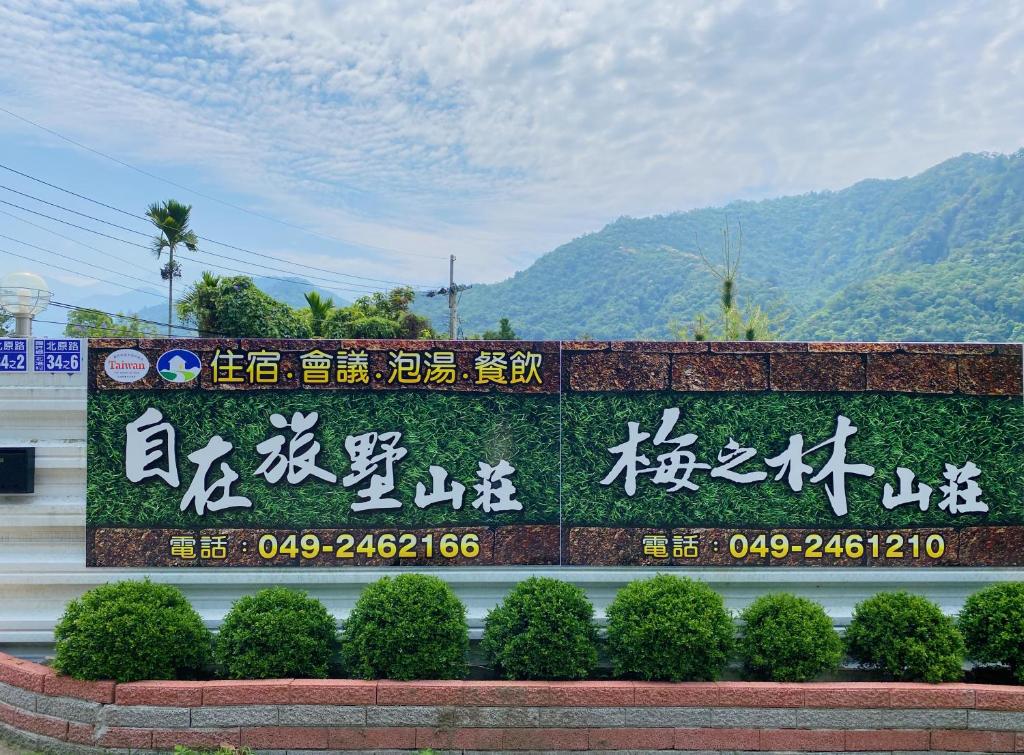 een bord met Chinees op een muur met bergen op de achtergrond bij 自在旅墅山莊 in Guoxing