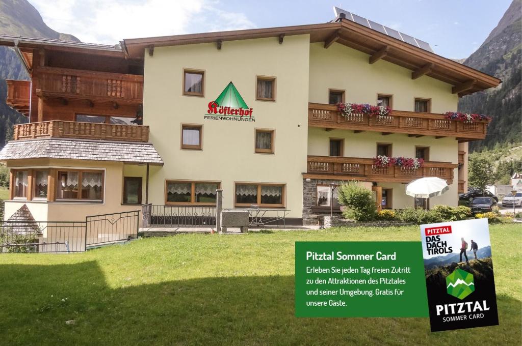 a hotel with a sign in front of it at Köflerhof Appartements in Sankt Leonhard im Pitztal