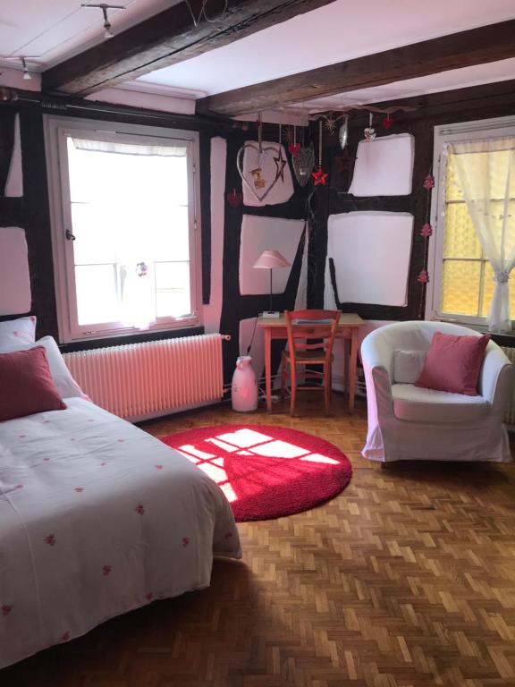 um quarto com uma cama e um tapete vermelho em Gîte Au Fil Du Temps em Colmar