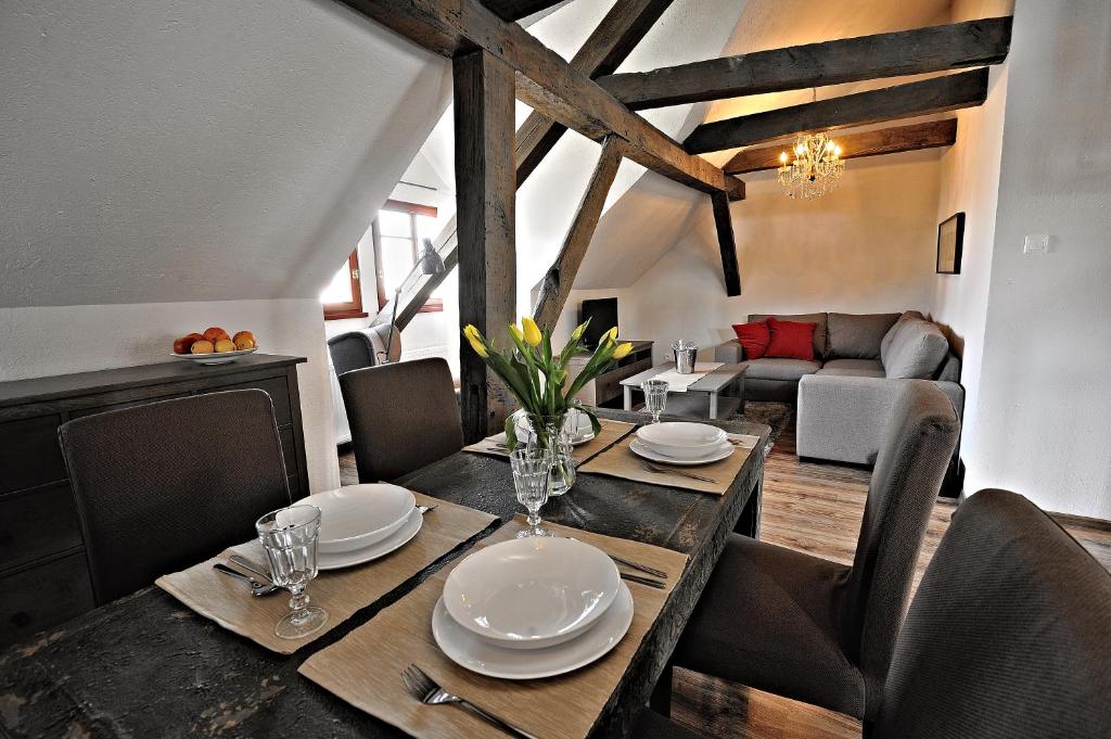 a dining room with a table with plates and glasses at Apartamenty Katarynka Stary Rynek in Bydgoszcz