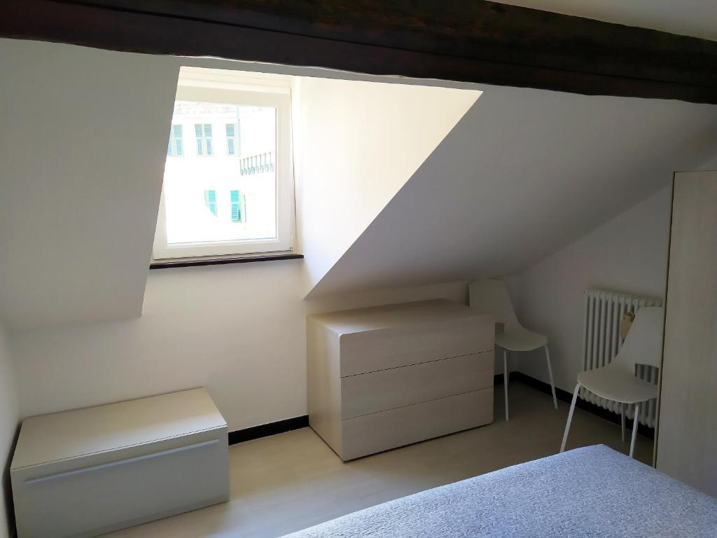 a attic room with a bed and a window at La mansarda sul Porto in Camogli