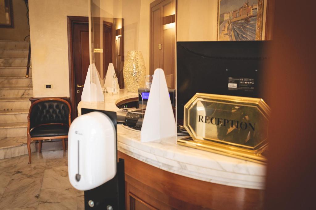 a hotel room with a reception counter with a pay phone at Hotel Posta in Cecina