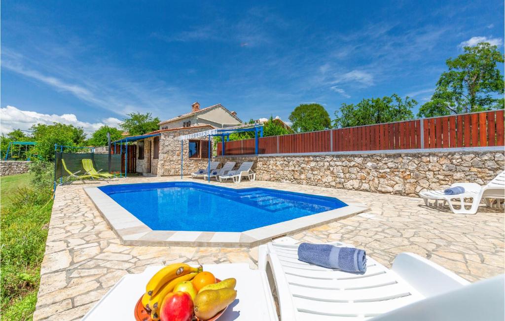 a pool with a bunch of fruit on a table at Gorgeous Home In Labin With Outdoor Swimming Pool in Labin