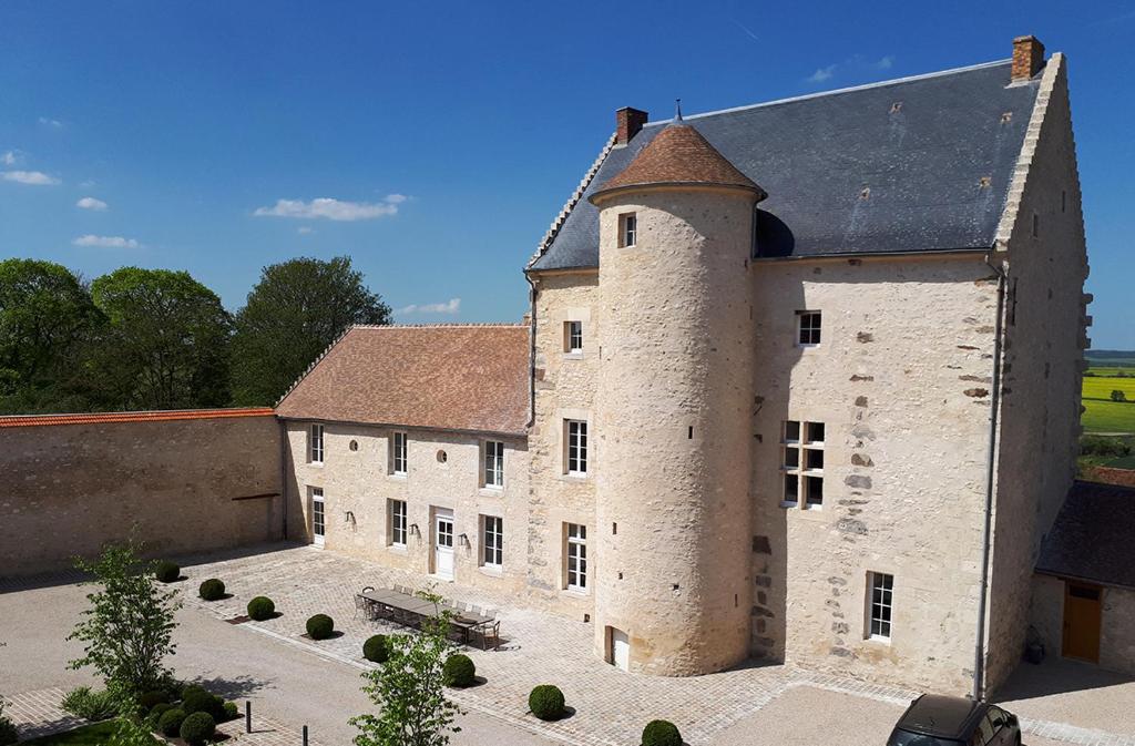 an old building with a tower on top of it at Ferme du Château in Anthenay