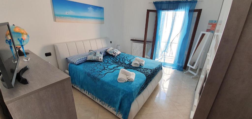 a bedroom with a blue bed with towels on it at Storico 3 in Monopoli