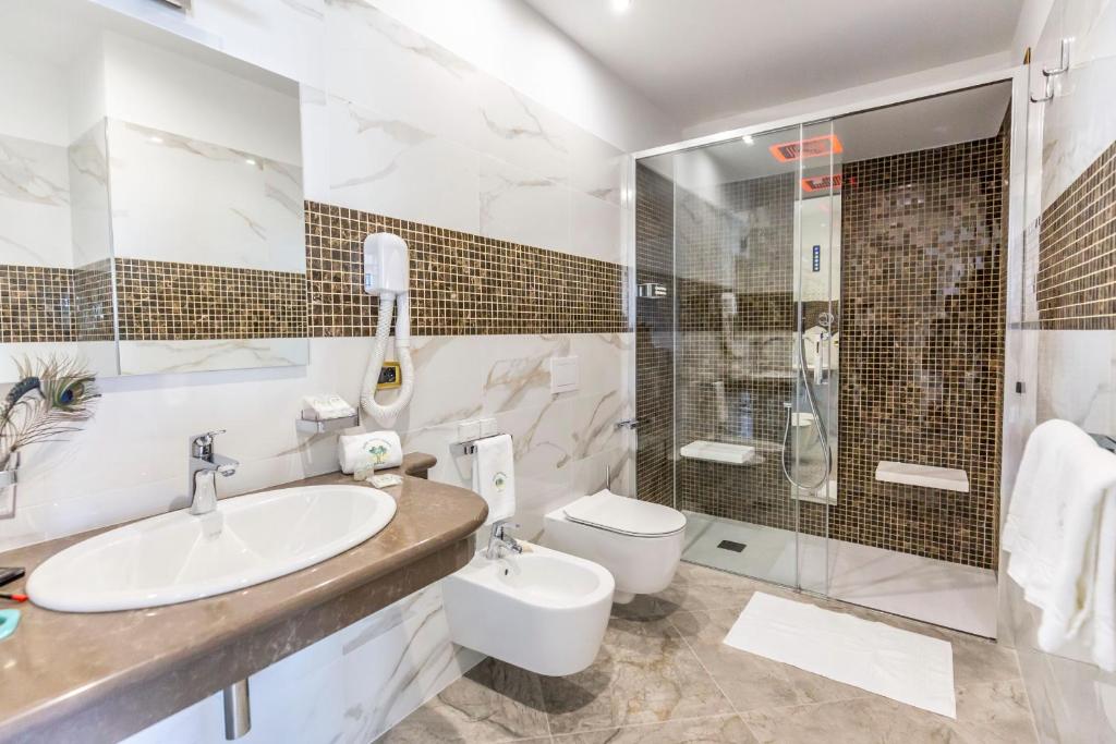 a bathroom with a sink and a toilet and a shower at Hotel Santa Chiara in Capo Vaticano