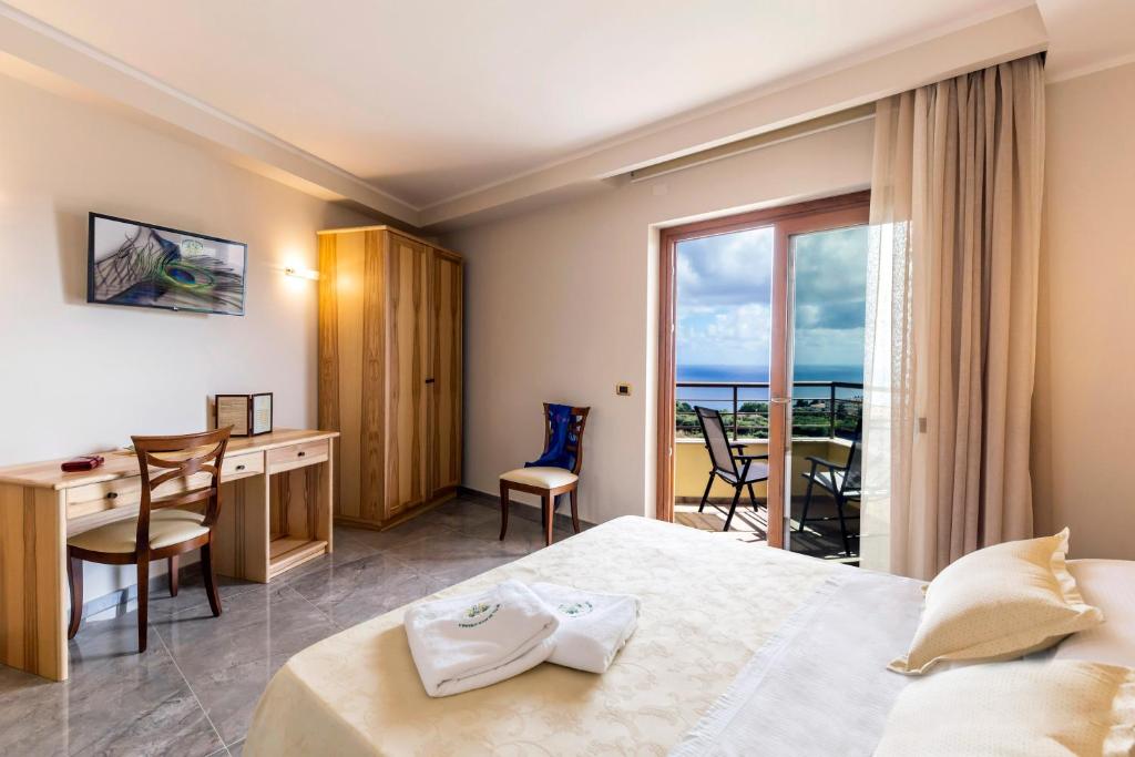 a hotel room with a bed and a desk and a window at Hotel Santa Chiara in Capo Vaticano