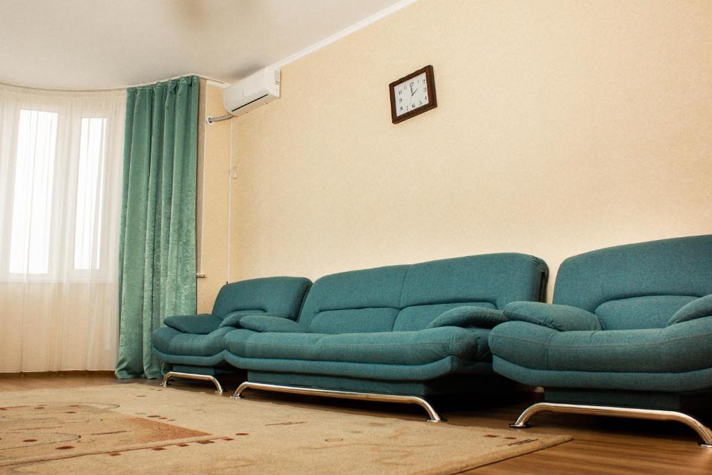 a living room with two blue couches in a room at Мода в доме 05 in Uralsk