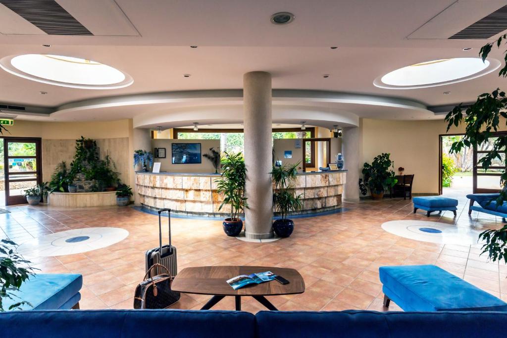 a lobby with blue couches and a table at Hotel Santa Chiara in Capo Vaticano