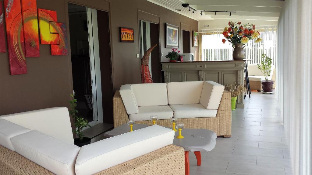 a living room with two white couches and a table at CHAMBRE PRIVEE AVEC SALON, garage voiture, vélos, motos in Tourville-sur-Arques