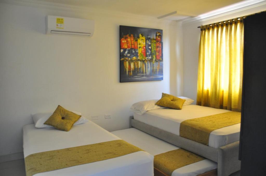 a room with two beds and a window at Casa Hotel Manga Mar in Cartagena de Indias